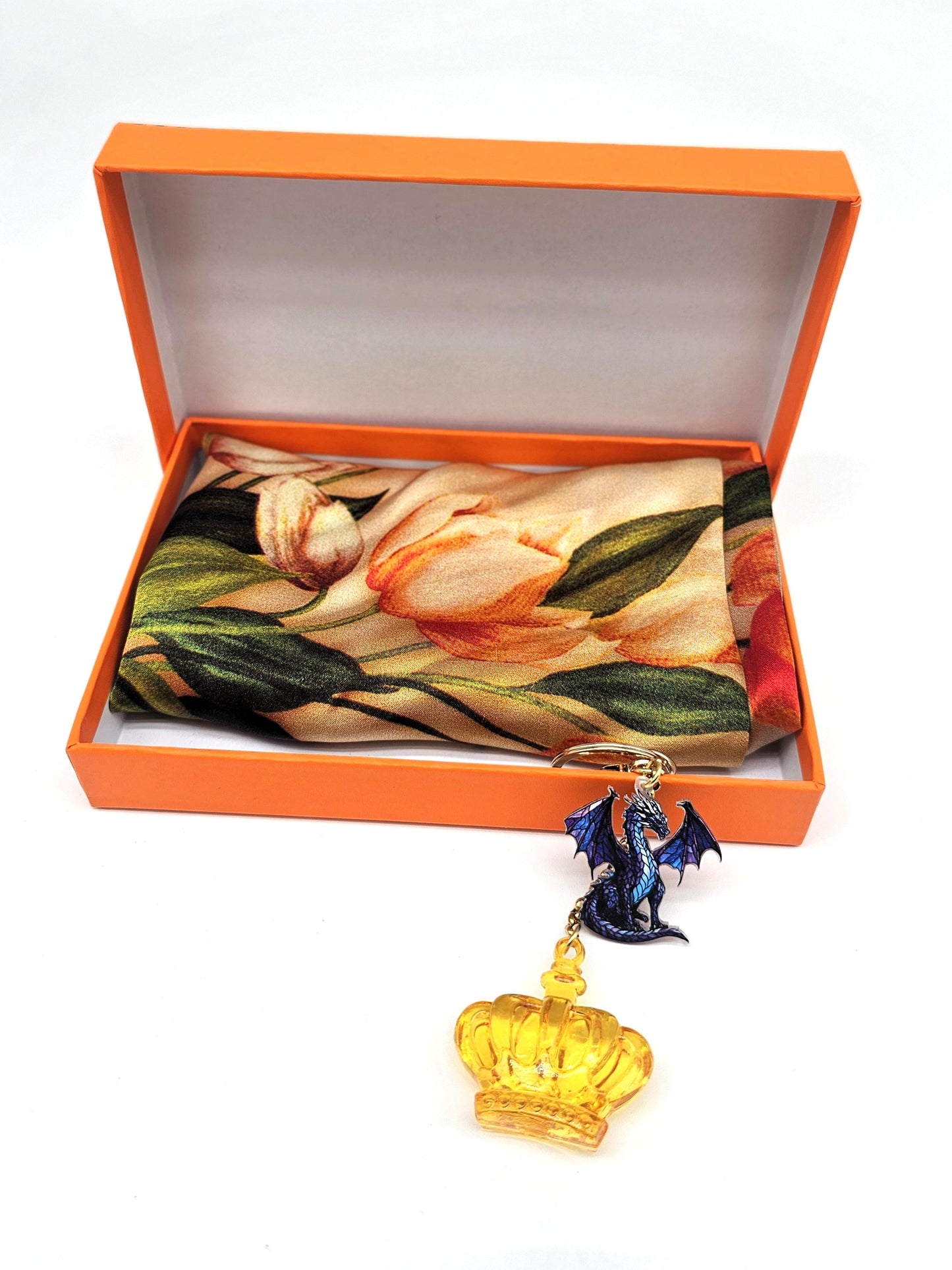 A fantasy-themed keychain with a purple dragon charm and a translucent golden crown, highlighted against a clean white backdrop.