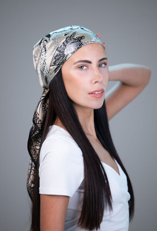 Model wearing a neutral botanical 100% mulberry silk headscarf with dark border