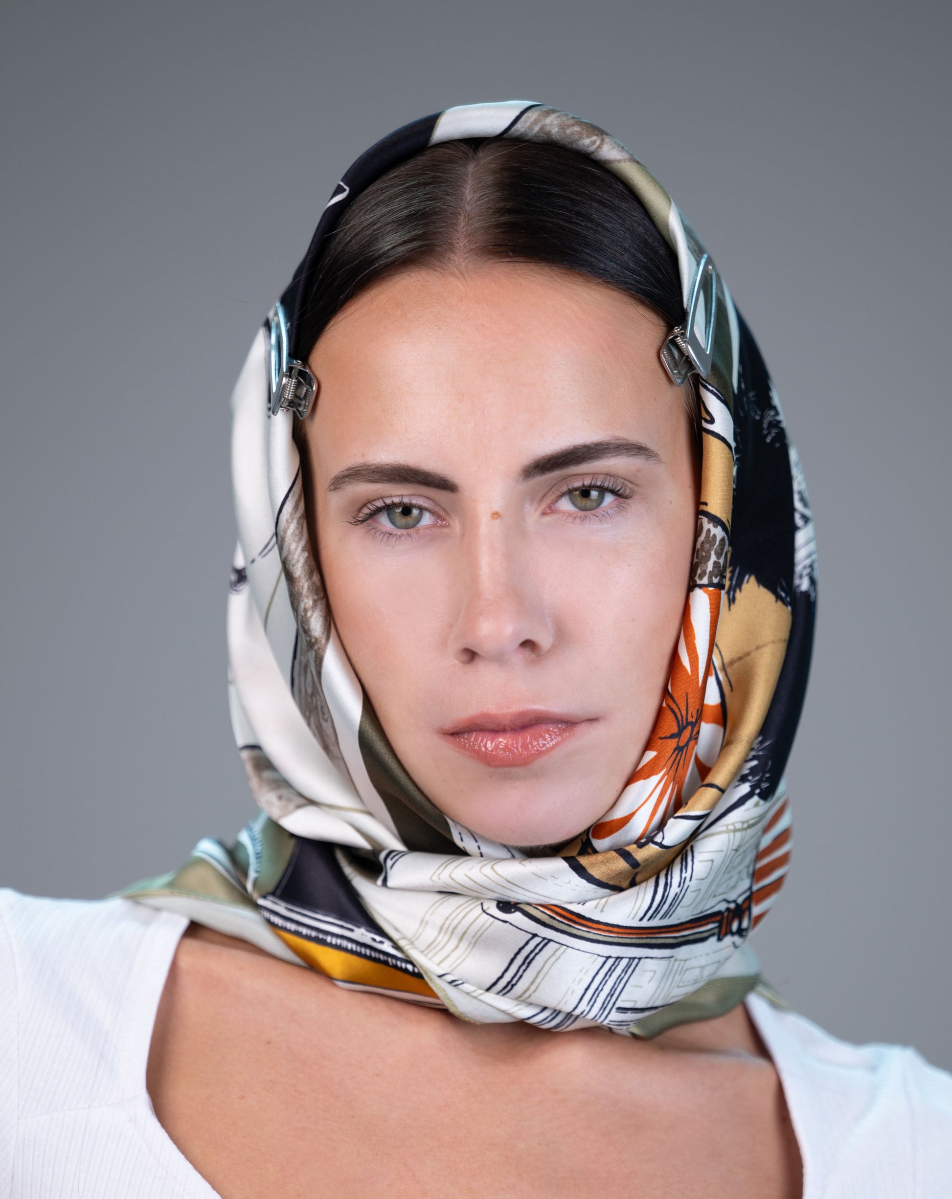 Model wearing 100% mulberry silk square scarf in olive/black/marigold print.