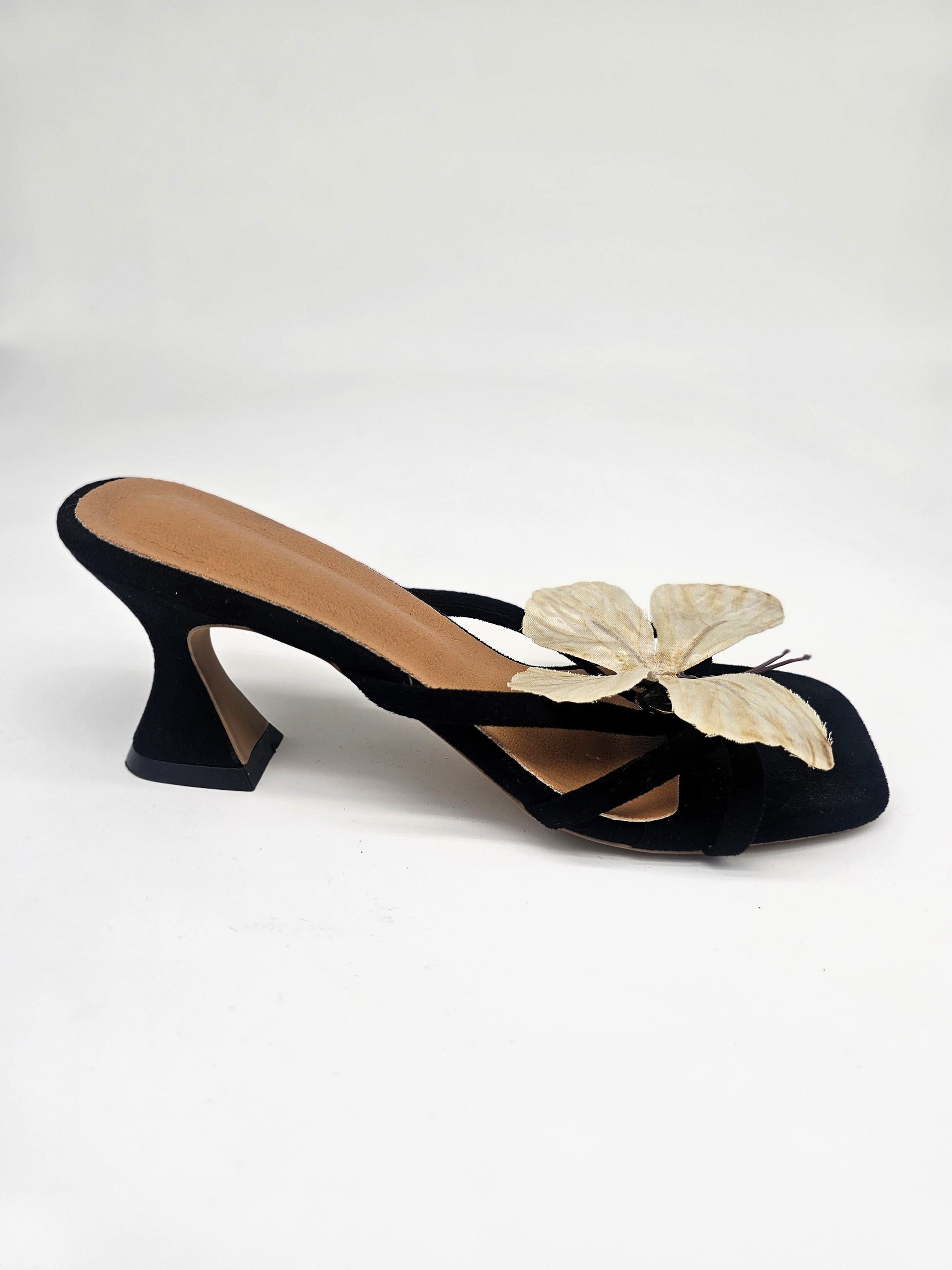 Black heeled sandals with cushioned sole and handcrafted beige butterfly detail, comfortable women’s heels for casual and formal wear.
