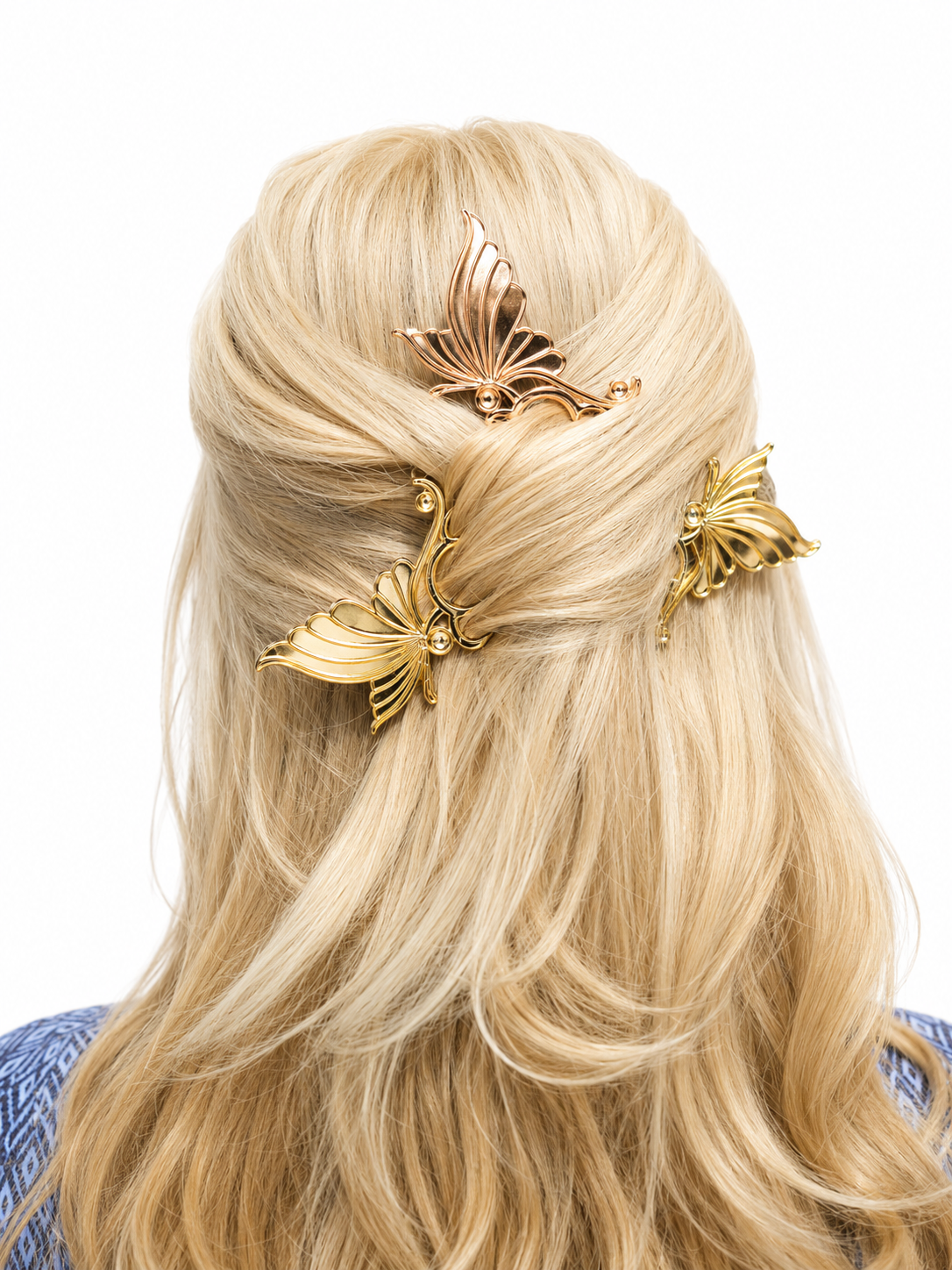 Blonde hair styled with gold butterfly hairpins on a white background