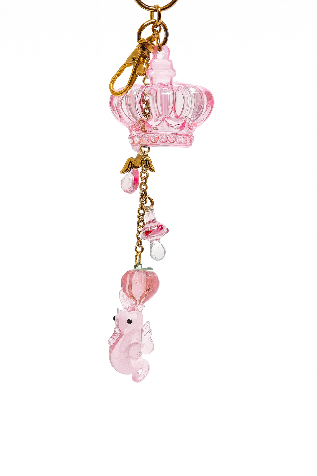 Cute pink keychain featuring a crown charm, glass lampwork seahorse, and decorative pendants on gold-plated steel.