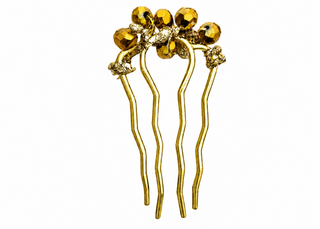 Gold hair comb with decorative elements on a white background