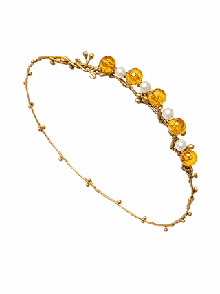 Gold headband with amber beads and pearls on a white background