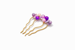 Gold hairpin with purple and pink beads on a white background