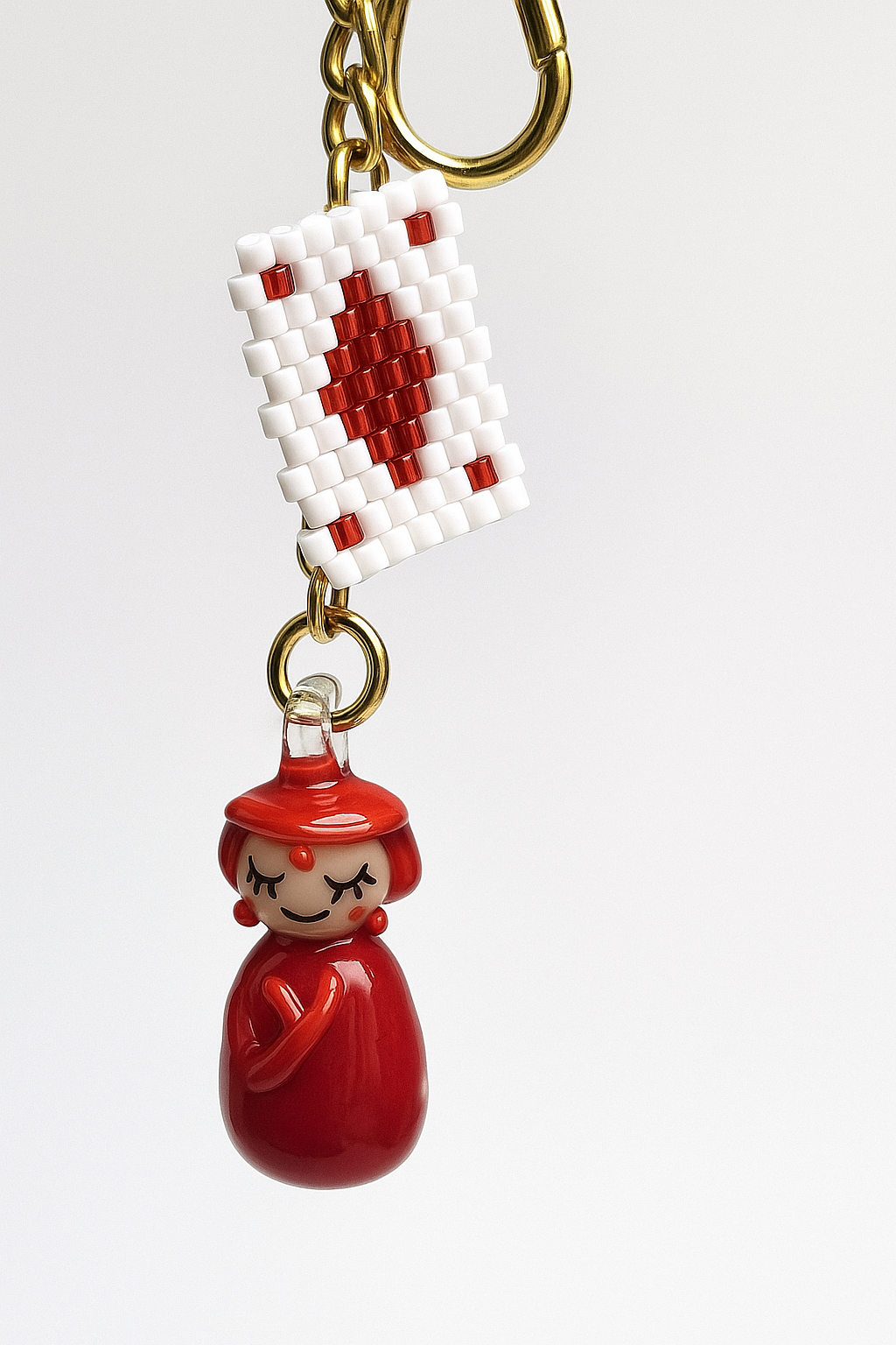 Unique keychain with red doll pendant and beaded Ace card charm on gold-plated stainless steel chain