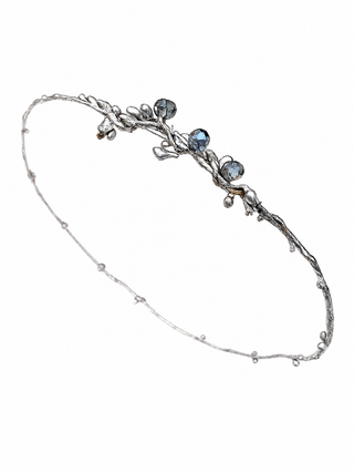 Silver headband with blue stones on a white background