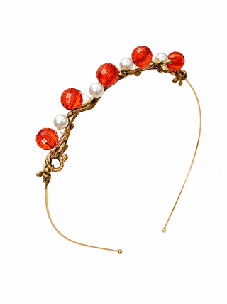 Decorative headband with red beads and gold accents on a white background