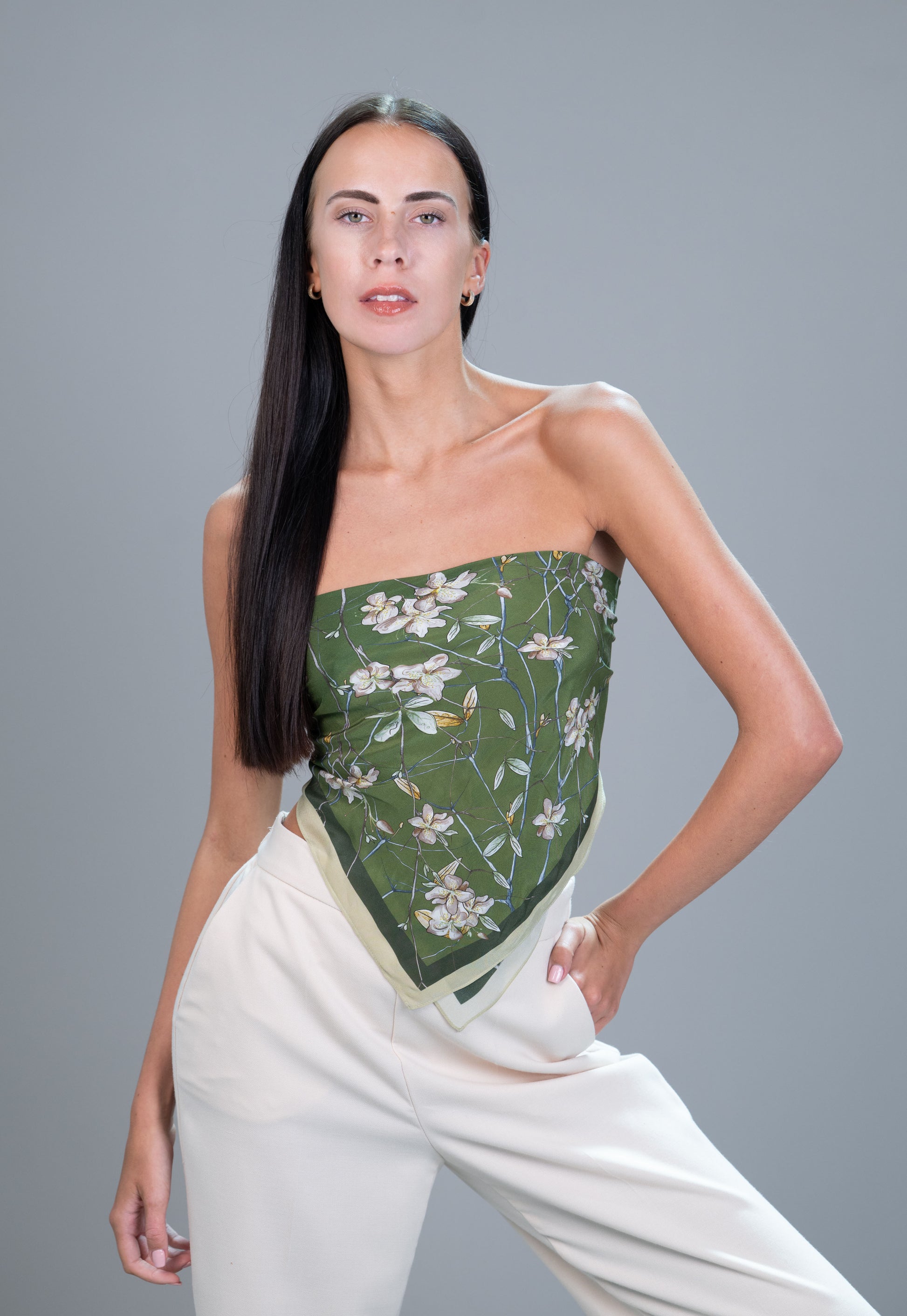 Model wearing a 55×55 cm green botanical 100% mulberry silk square scarf styled as a top.