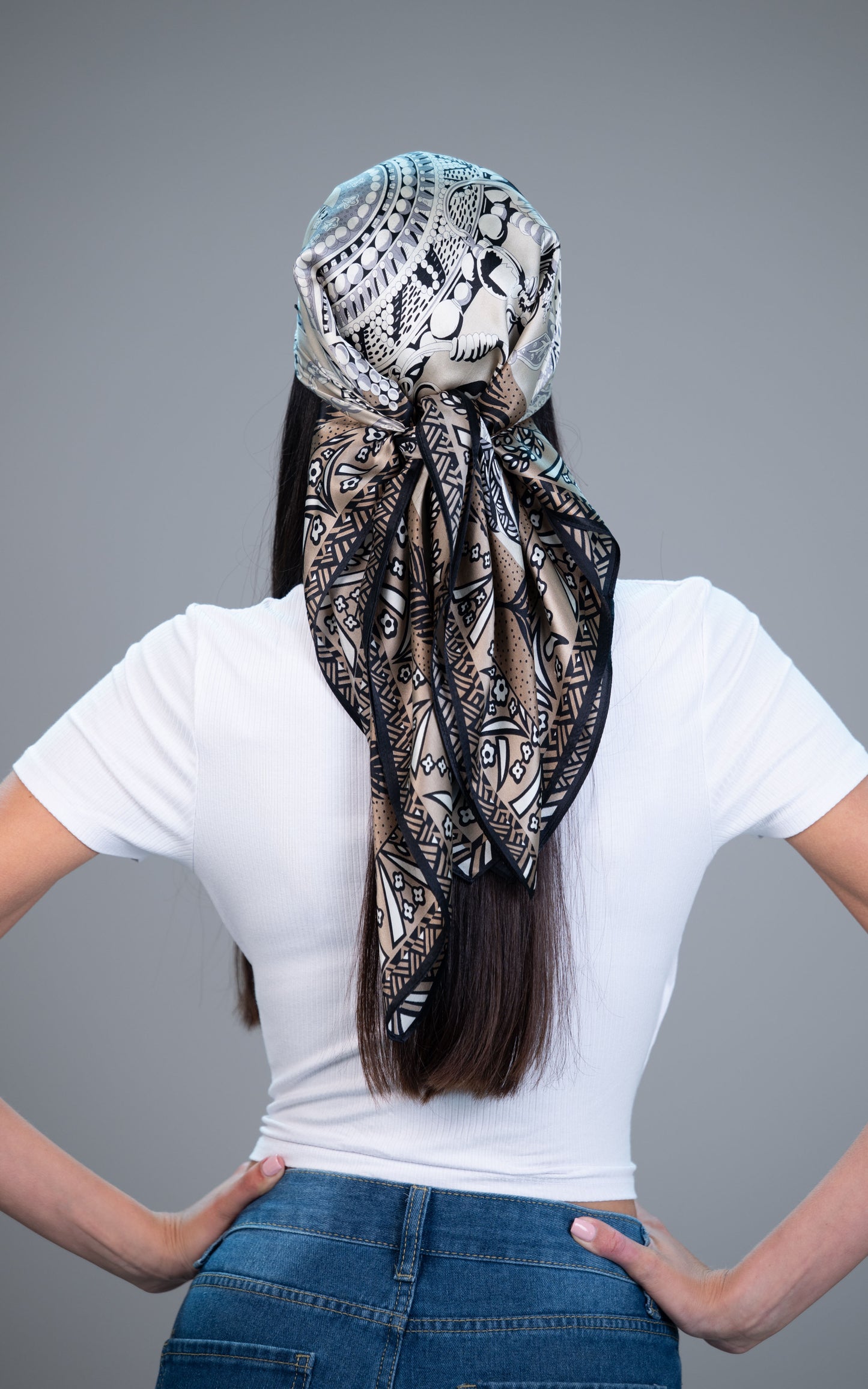 Model wearing a neutral botanical 100% mulberry silk headscarf with dark border