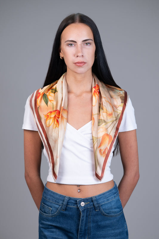 Model wearing an orange floral 100% mulberry silk scarf with brown borde