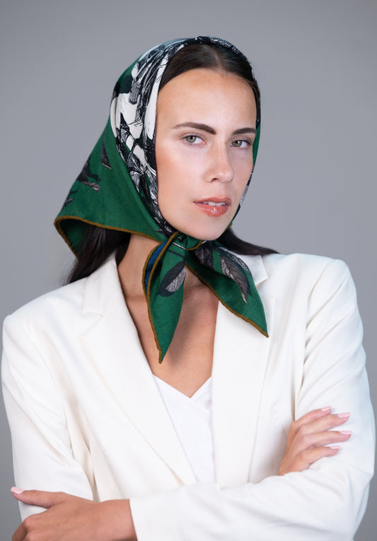 Model wearing a green horse-print reversible cashmere–silk scarf with hand-rolled edges, designed in England.