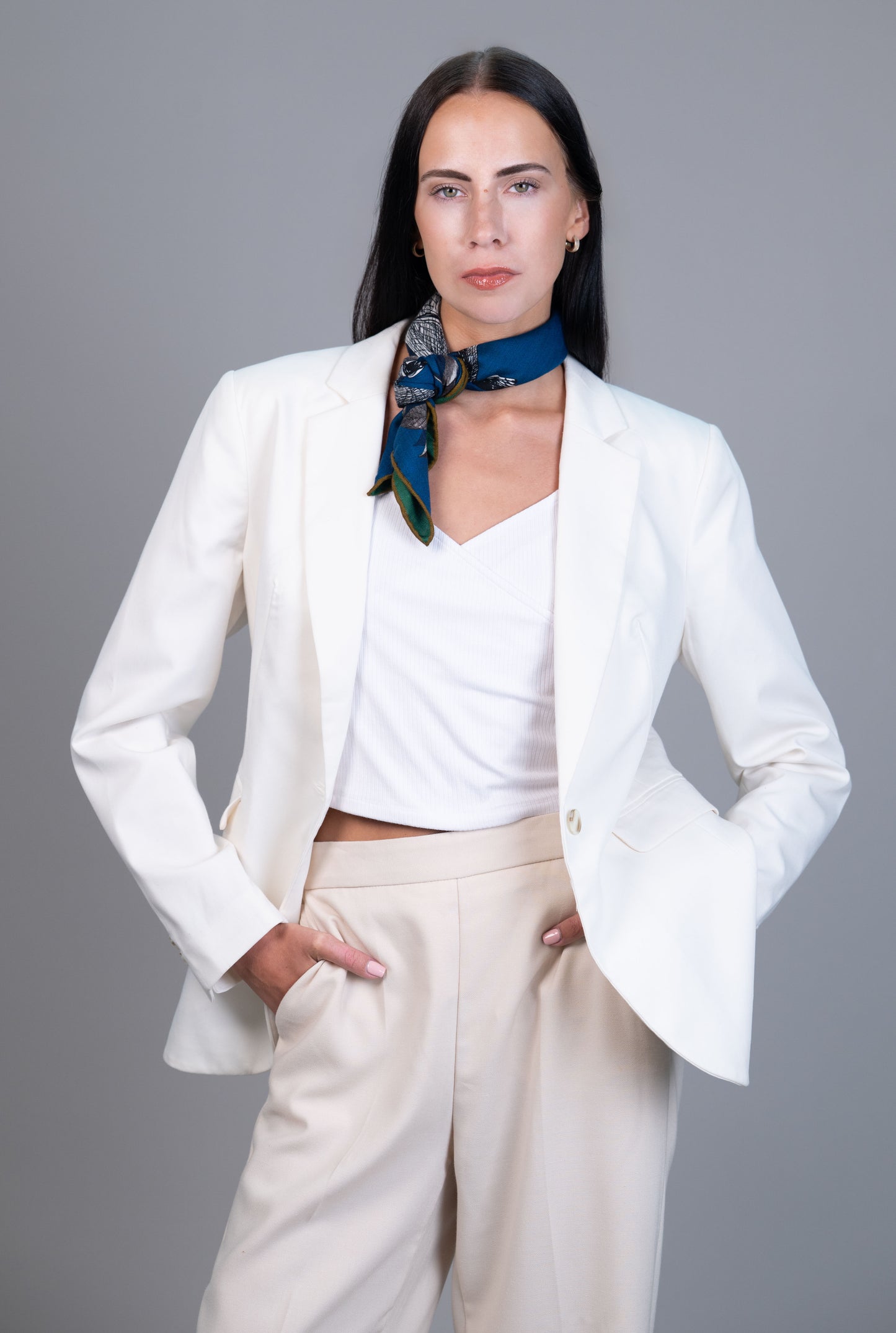 Teal reverse side of reversible cashmere–silk horse print scarf tied at the neck.